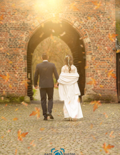 Hochzeit-Paar-Braut-Bräutigam-Herbst-Sonne-Burg-Brautkleid-Hochzeitskleid-Anzug-Gemeinsam-gehen-Baer.Photos-Fotograf-Holger-Bär